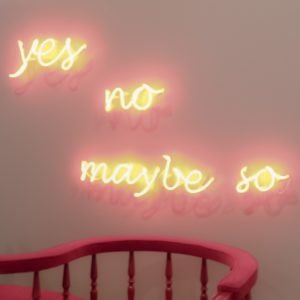 scritta la neon su un muro: yes, no, maybe so. 